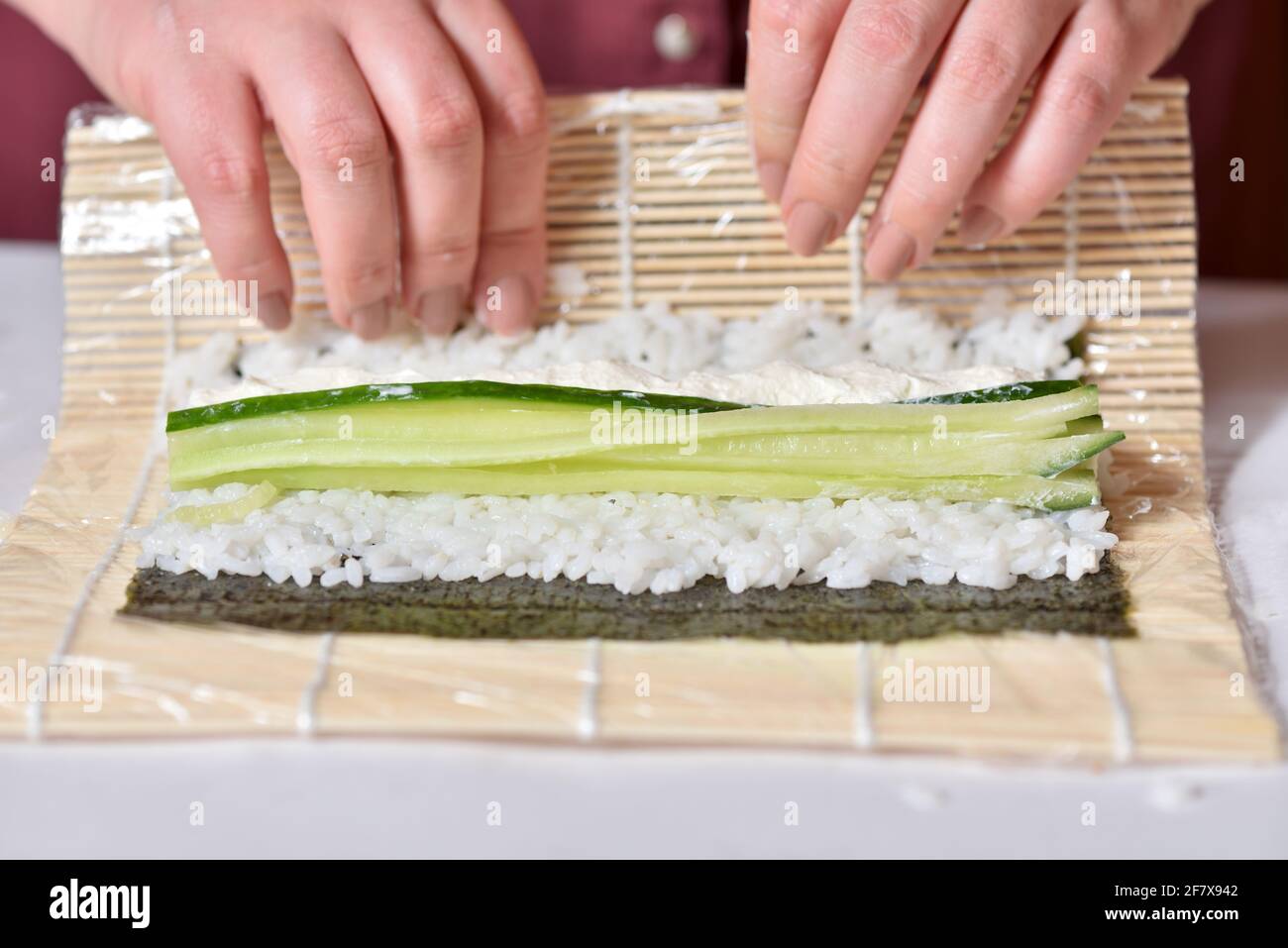 Cucina di sushi roll fatto in casa con cetriolo Foto Stock