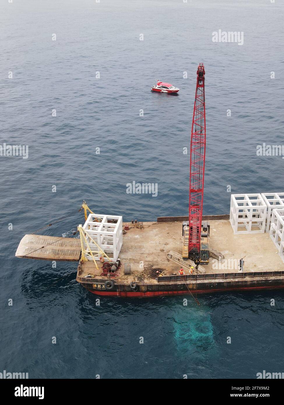 (210410) -- HAIKOU, 10 aprile 2021 (Xinhua) -- in questa foto aerea scattata il 1° aprile 2021, il personale posò barriere coralline artificiali intorno all'isola di Wuzhizhou nella città di Sanya, nella provincia di Hainan, nella Cina meridionale. L'Isola di Wuzhizhou ha lanciato un'unità completa per costruire un ranch marino e ripristinare l'ecosistema marino, mettendo barriere coralline artificiali sotto il mare e trapiantando coralli. Alla fine del 2020, il ranch marino dell'isola di Wuzhizhou ha posto 1,526 barriere coralline artificiali. E altri 870 saranno deposti entro un mese nel recente posizionamento artificiale delle barriere coralline. (Xinhua/Zhang Liyun) Foto Stock