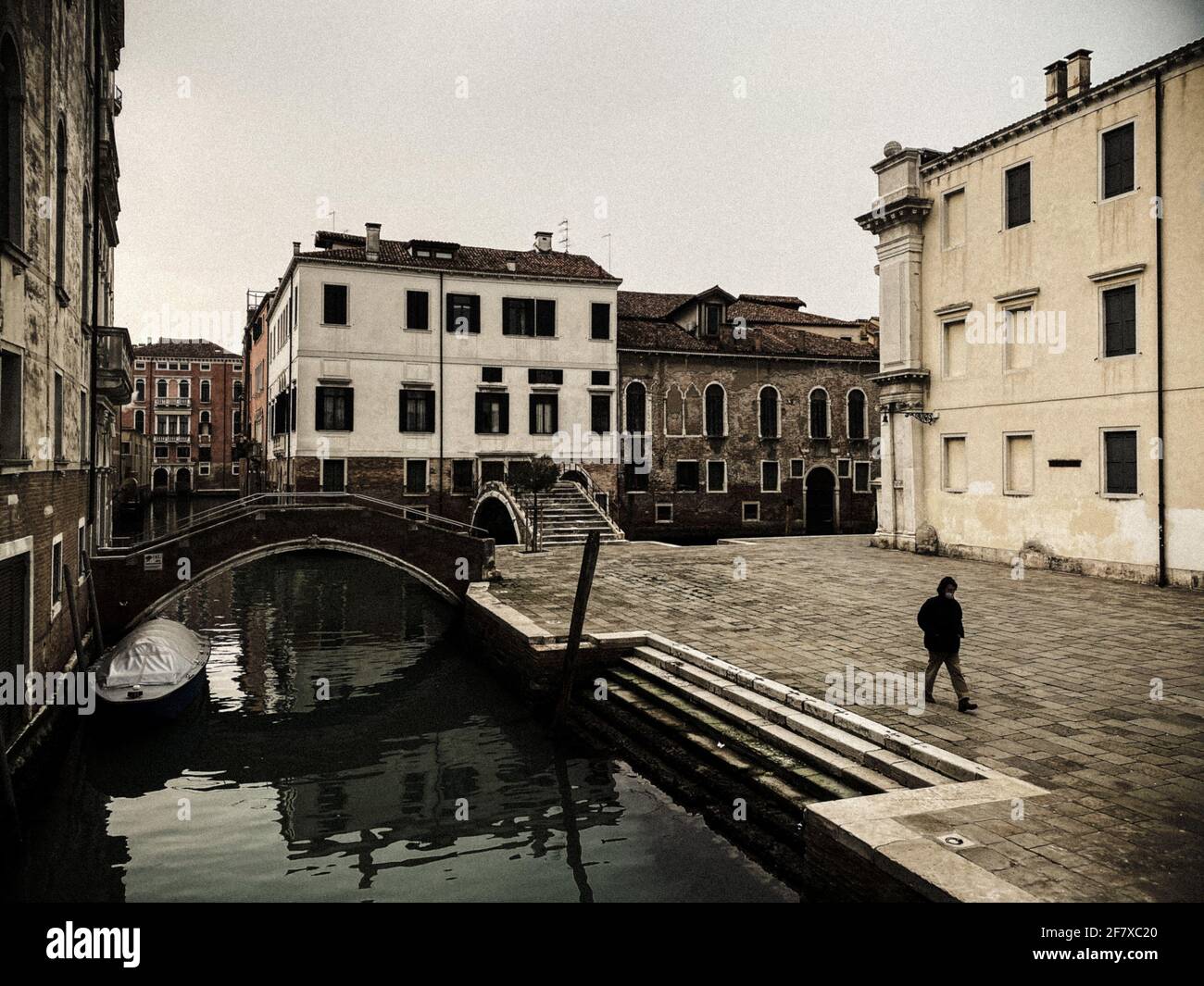 Una gente irriconoscibile che indossa una maschera che cammina in una piazza a Venezia, italia, durante la crisi COVID-19 Foto Stock