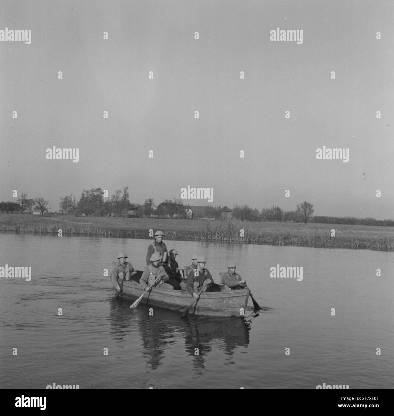 I soldati usano una barca a remi in tela per attraversare un canale. Foto Stock