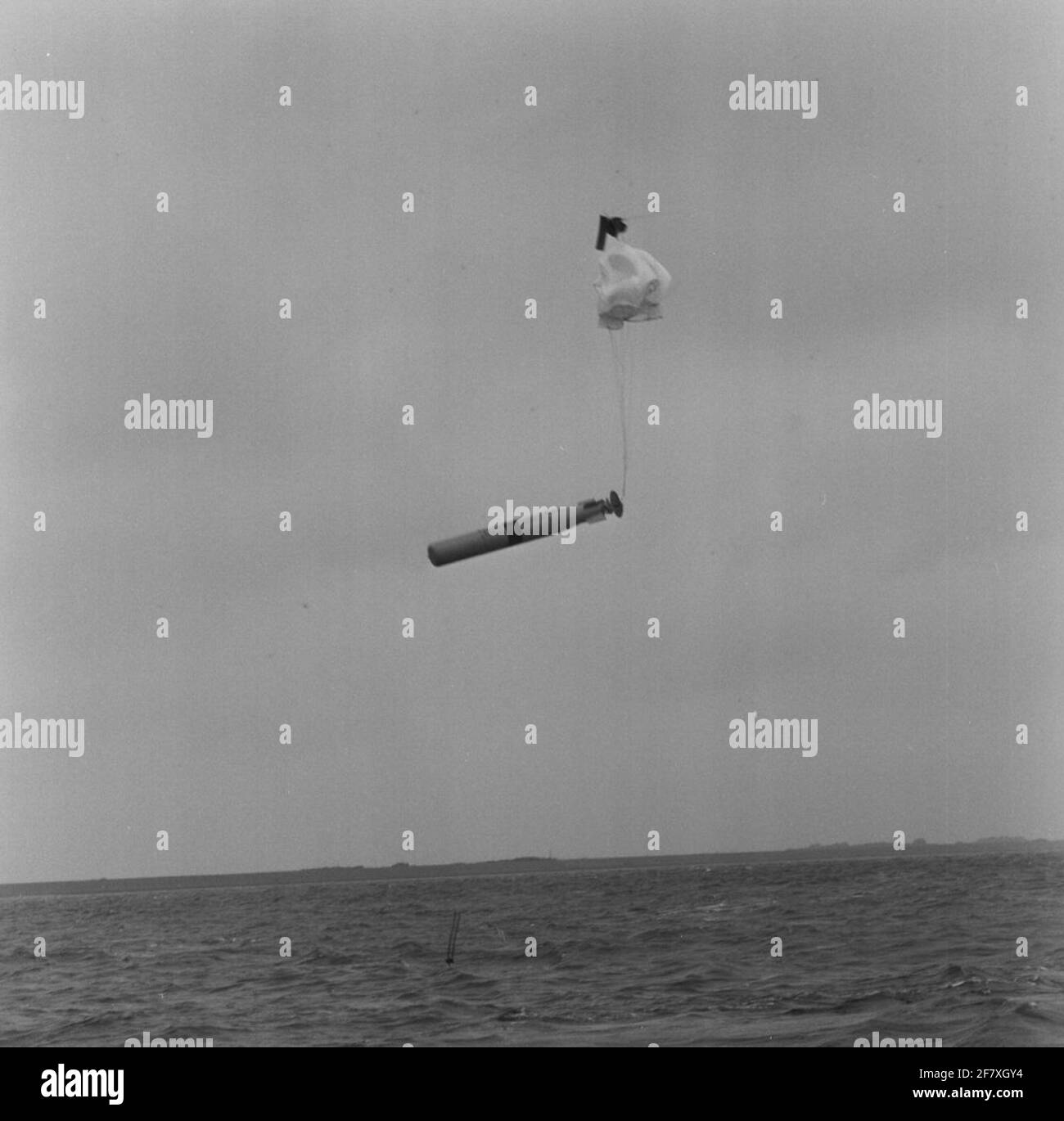 Siluro fittizio mk 44 capannato da un elicottero di Westland Lynx. Il parachut che si apre lì è quello di garantire che il siluro venga ad acqua. Il parachut è scollegato dal siluro al centro. Foto Stock