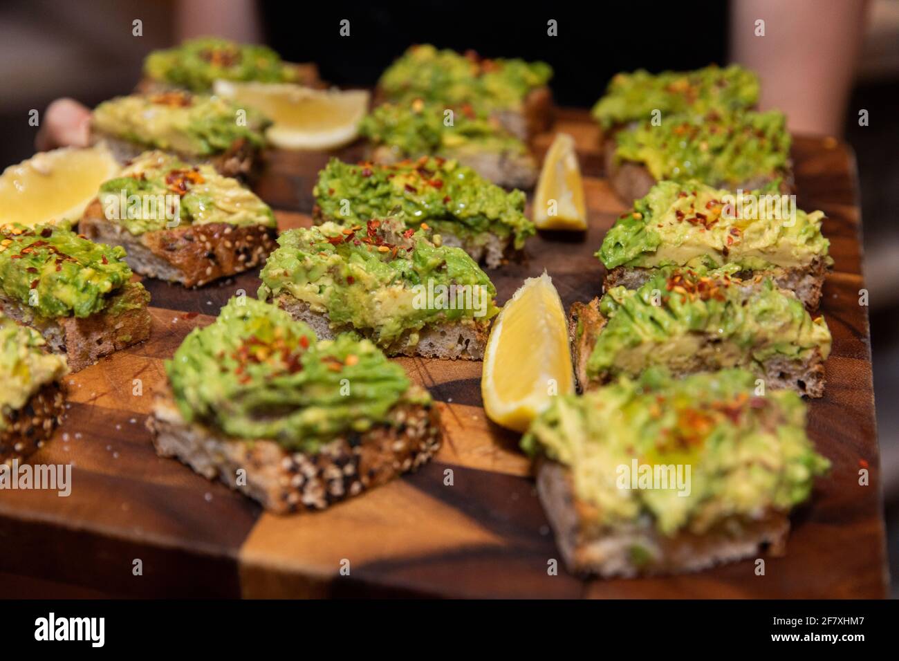 toast di avocado a fette in una festa servita su un legno piastra Foto Stock