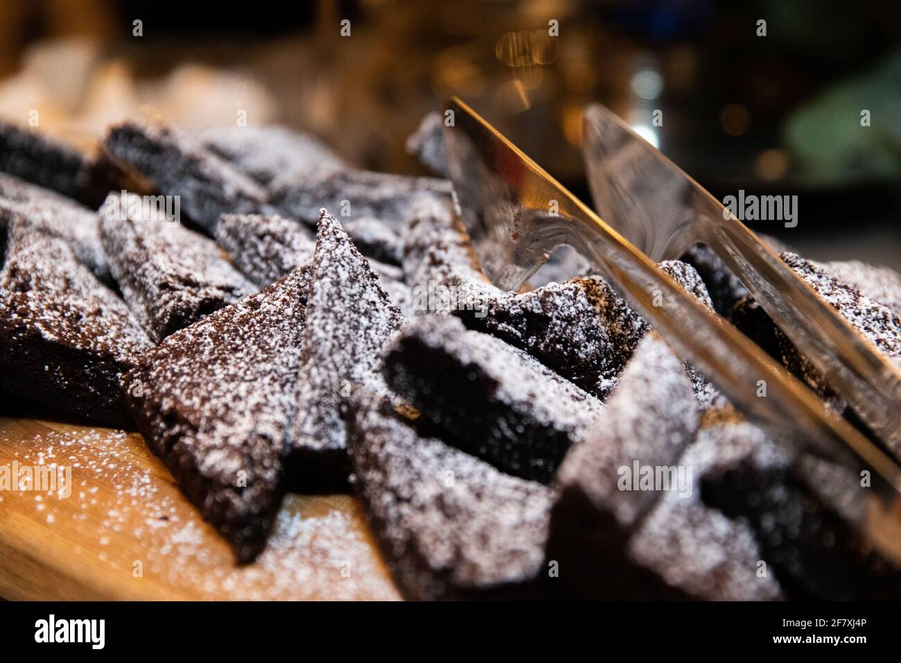 porzioni di brownie di cioccolato su un piatto con zucchero su e. thong cucina metallo Foto Stock