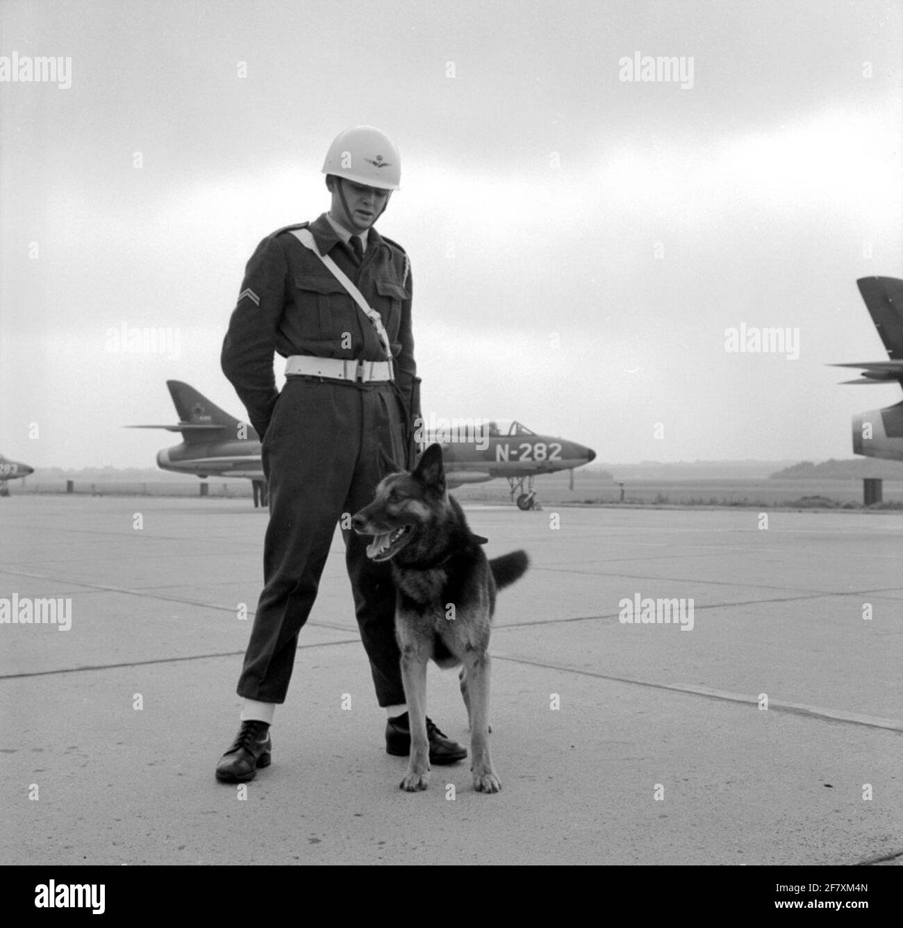 Un corporale-aria forza monitor con il suo cane pastore. Sullo sfondo un Hawker Hunter Mk.6 di 325 squadron.div. Argomenti di assistenza. Foto Stock