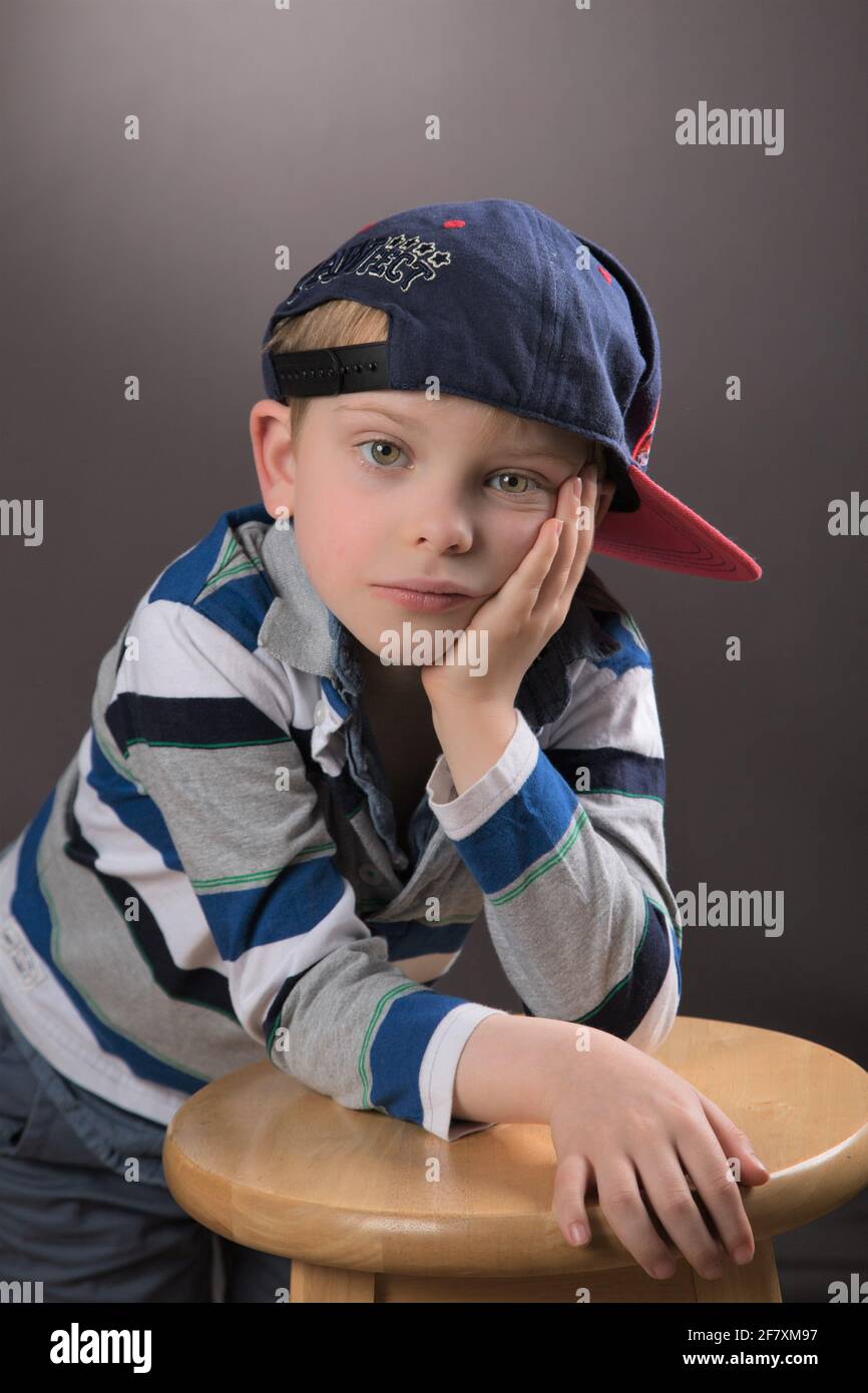 Il giovane ragazzo che indossa il cappuccio sembra fresco in una posa studio. Foto Stock
