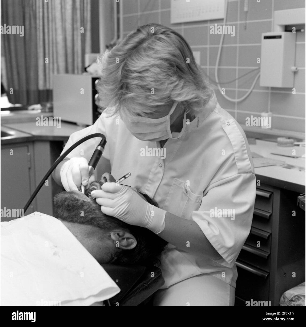 Un dentista della malattia centrale (CZB) nella caserma marina Willemsoord (MKWD) in Den Helder esamina i denti di un paziente (luglio 1989). Foto Stock