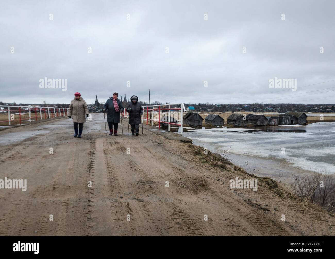Aprile 2021 - Nyonoksa. Gli abitanti del villaggio camminano lungo una  strada di campagna con villaggi e templi sullo sfondo. Russia, regione di  Arkhangelsk Foto stock - Alamy
