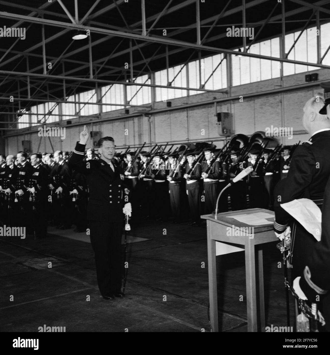 In un hangar del MarineLiegkamp Valkenburg (MVKV), si svolge un giuramento di 9 ufficiali di dipartimenti commerciali dal comandante del MVKV, Captain-Ter-Sea kite (KTZV) G.F. Venema. Un funzionario dei servizi commerciali è un funzionario secondario che è nominato ufficiale. In questo caso al Lieutenente-Mare dei dipartimenti ​​trade della seconda classe (LTZVK 2). Foto Stock