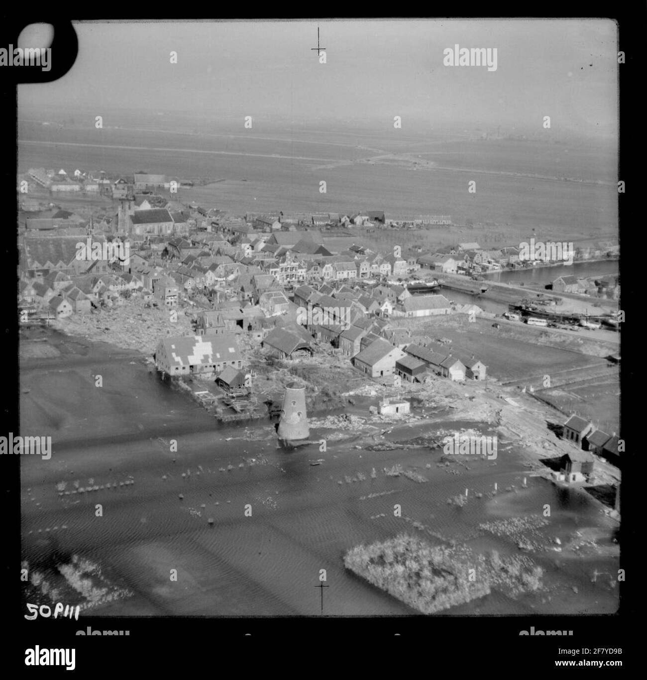 Carenza di acqua 1953. Foto aerea di Oude-Tonge con una panoramica della zona colpita dal disastro. Da destra a metà dell'antica Tonge Benedsa (acqua) con il palazzo sul molo, sopra la chiesa riformata e a sinistra la Chiesa di nostra Signora dell'Ascensione. Il mulino senza lame è il resto del Mill de Late (mulino di Jacobs) sul Zuiddijk nel 1936. Foto Stock