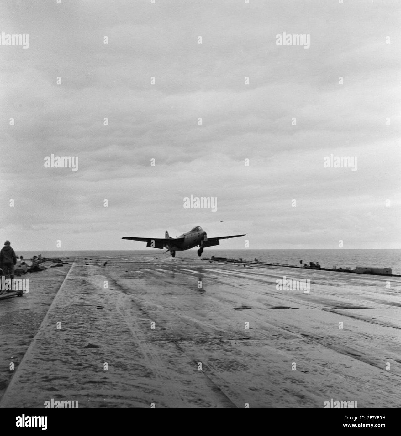 L'aereo Hawker FGA-50 Seahawk (RADIUS) con registrazione 61 (1957-1959) del Marine Aviation Service (MLD) atterra sul ponte aereo del campo aereo hr.ms. Karel Doorman (R 81, ex venerabile) nel 1958. Il gancio del freno sulla coda del cacciatore ha uno dei cavi del freno per afferrare il ponte di volo. Foto Stock