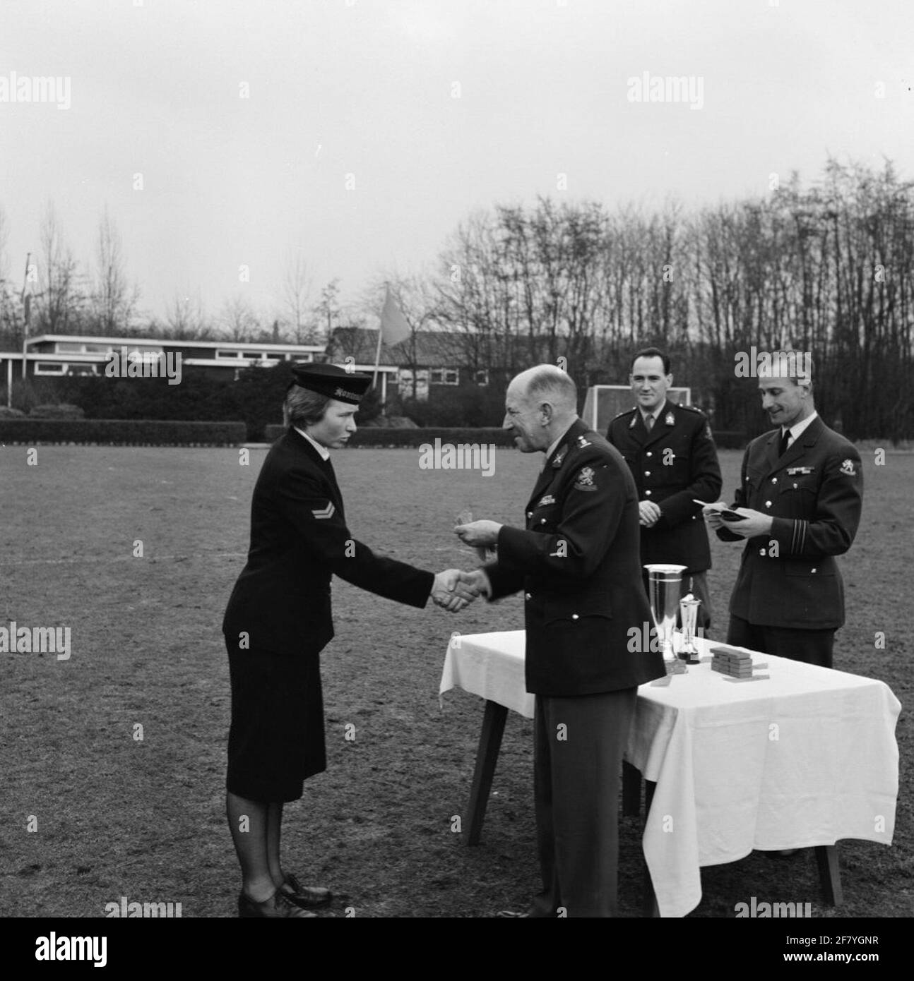 Campionati militari di hockey a Rijswijk. Una marva principale di terza classe (Hmarva 3) [HMVA 3] riceve un premio da un colonnello della Royal Netherlands Army (KL). Dietro di lui ci sono un primo tenente della KL e un maggiore della Royal Air Force (KLU). Foto Stock