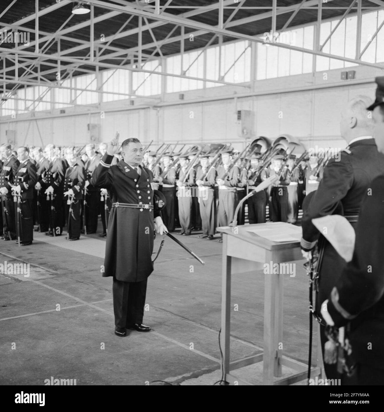 In un hangar del MarineLiegkamp Valkenburg (MVKV), si svolge un giuramento di 9 ufficiali di dipartimenti commerciali dal comandante del MVKV, Captain-Ter-Sea kite (KTZV) G.F. Venema. Un funzionario dei servizi commerciali è un funzionario secondario che è nominato ufficiale. In questo caso al Lieutenente-Mare dei dipartimenti ​​trade della seconda classe (LTZVK 2). Foto Stock