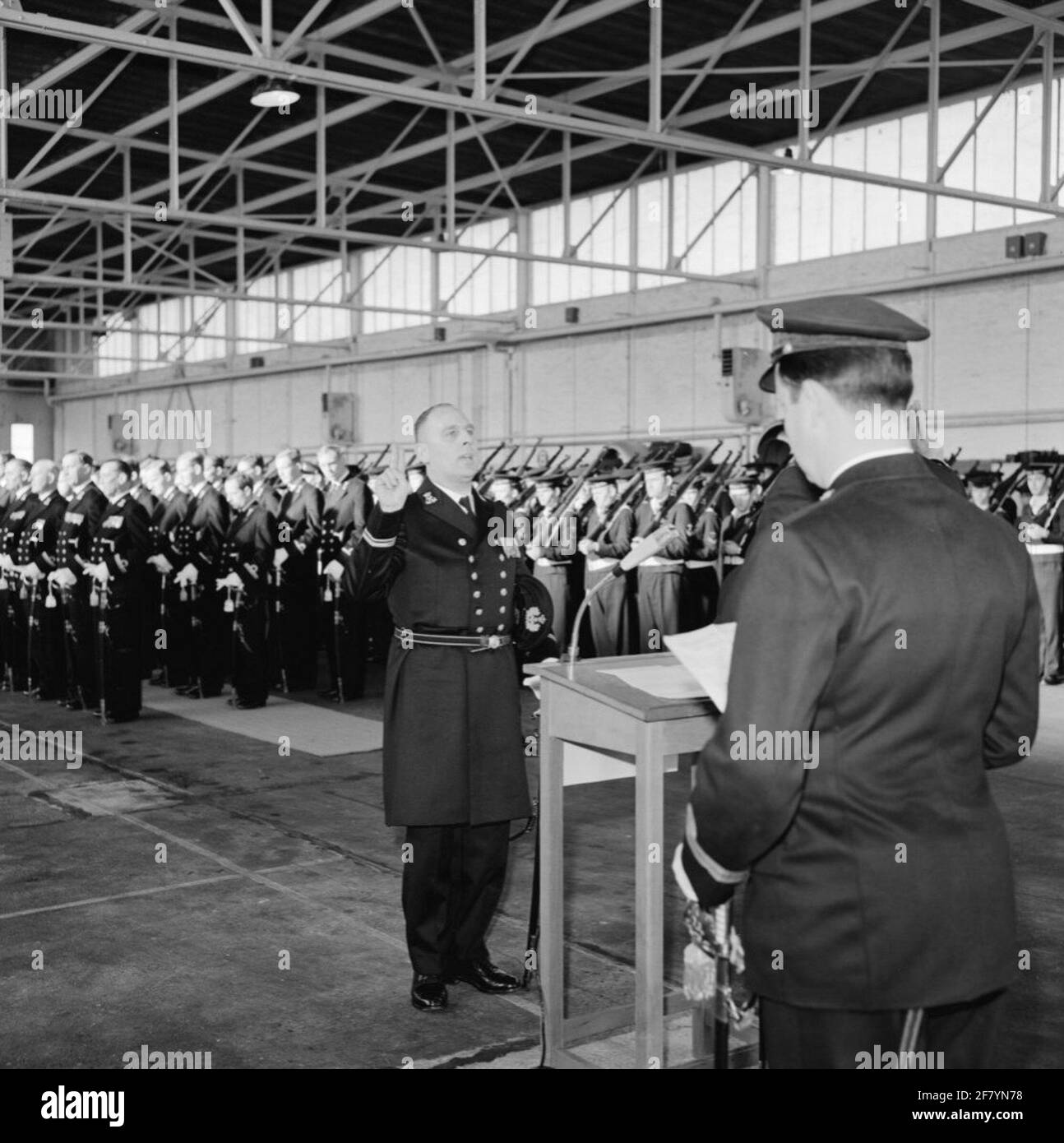 In un hangar del MarineLiegkamp Valkenburg (MVKV), si svolge un giuramento di 9 ufficiali di dipartimenti commerciali dal comandante del MVKV, Captain-Ter-Sea kite (KTZV) G.F. Venema. Un funzionario dei servizi commerciali è un funzionario secondario che è nominato ufficiale. In questo caso al Lieutenente-Mare dei dipartimenti ​​trade della seconda classe (LTZVK 2). Foto Stock