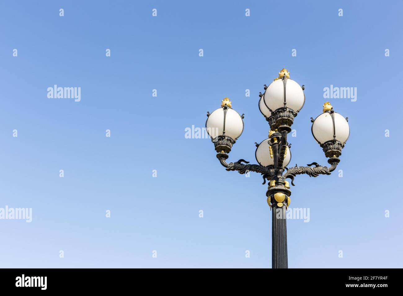 Lampada da strada in stile Vingate con ornamenti dorati e lampadine rotonde contro il cielo blu chiaro, Dubai, Emirati Arabi Uniti. Foto Stock