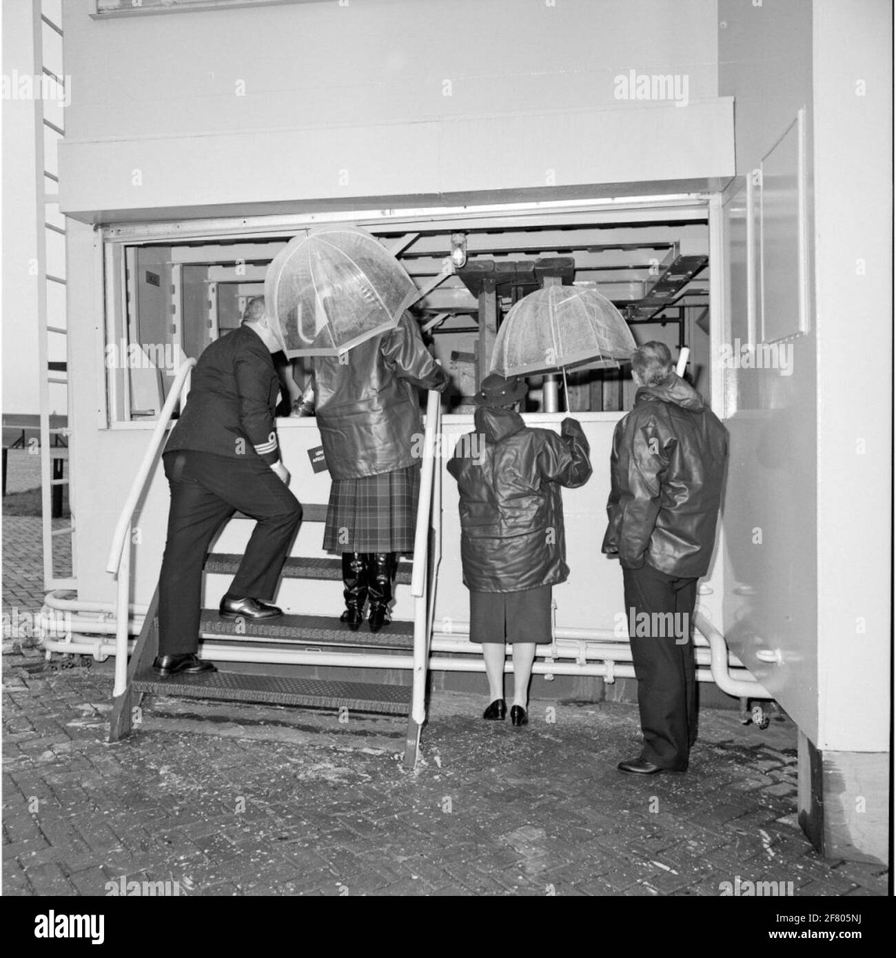 Visita l'HM Queen Beatrix (secondo da sinistra) alla scuola di NBCD (nucleare, batteriologico, chimico, controllo dei danni) e la sicurezza operativa a Den Helder nel marzo 1989. HM vedere la cosiddetta 'moot bagnato' qui, dove si può praticare nella lotta contro le calamità per quanto riguarda la resistenza all'acqua delle navi. Tutta la sinistra il capo della scuola di NBCD Captain-Lieutenant-Ter-Zee B.J.H.H. Rous (1941-1999). Foto Stock