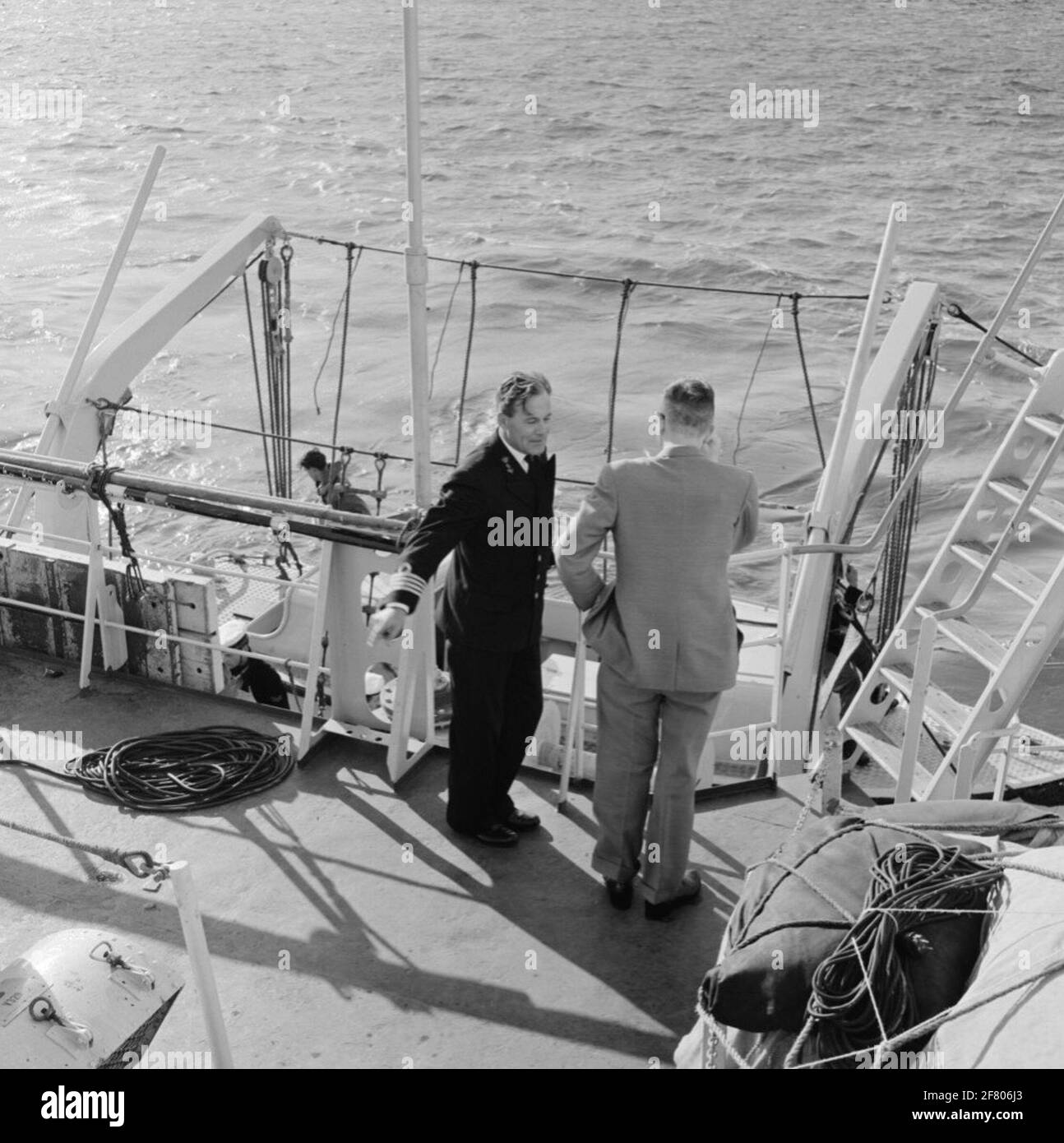 Il professor Witkamp sta navigando a bordo di HR.MS Friesland (D 812) (1956-1979), responsabile sottomarino della classe Frisia. Il professore in conversazione con un capitano-per-mare (KTZ) mentre uno slop è abbassato. Foto Stock