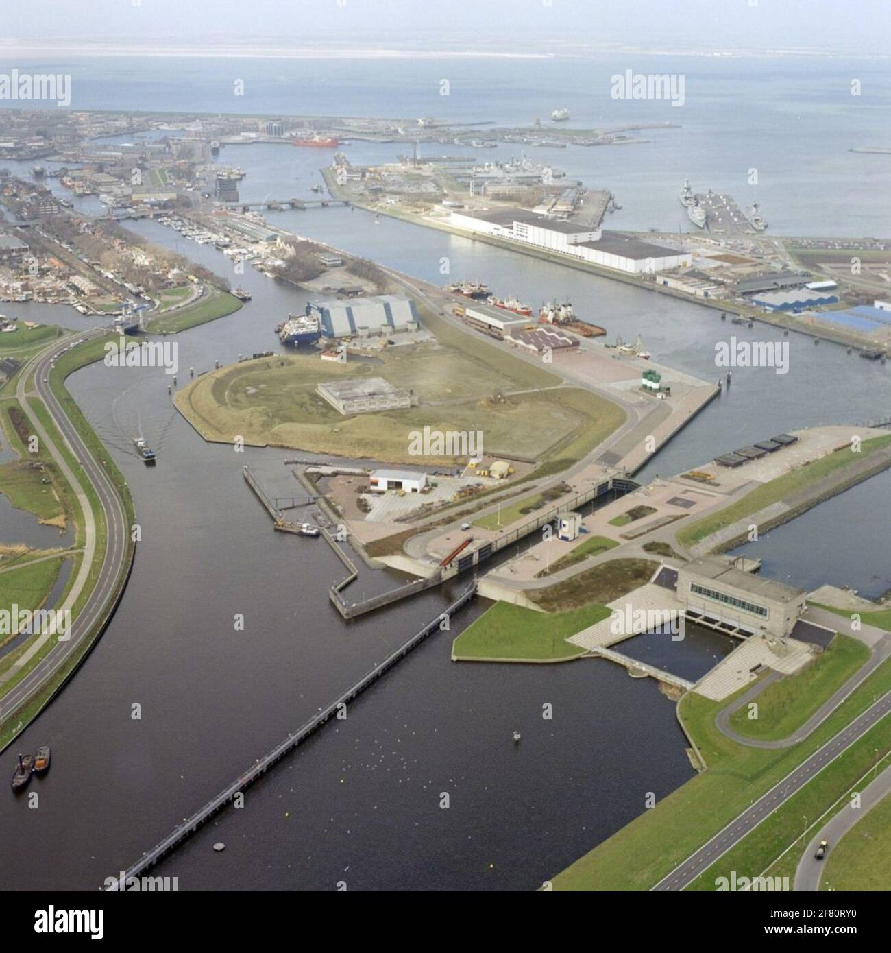 Registrazione aerea di una parte del porto di Den Helder con un po 'a sinistra sopra il Vice-Admiraal Moorman Bridge (1954) sotto il Koopvaarderslichtluis nel marzo 1990. Foto Stock