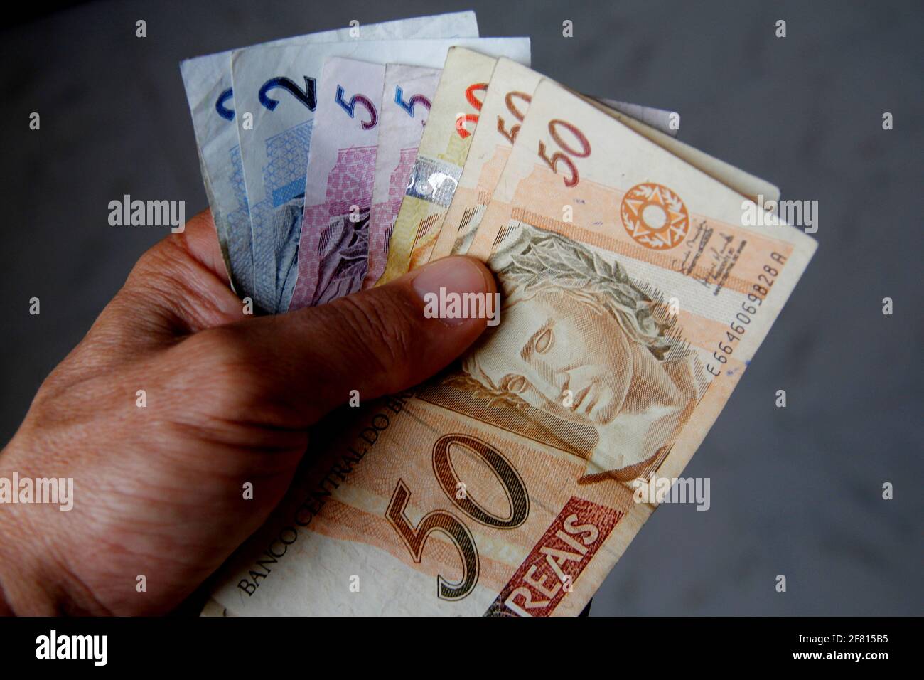 salvador, bahia / brasile - 19 gennaio 2013: Tenere a mano brasiliano banconote in valuta reale. *** Local Caption *** Foto Stock