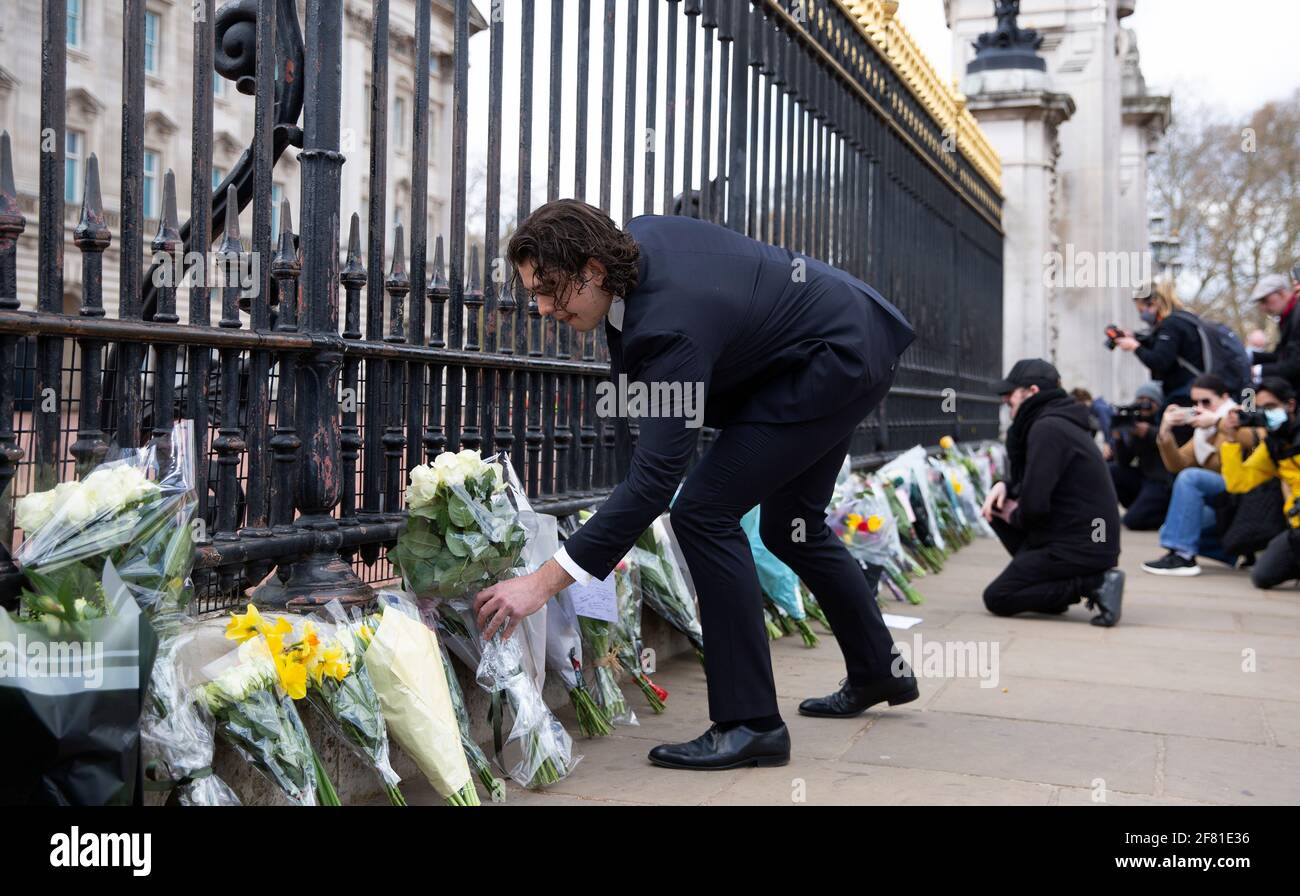 La gente ha posto i fiori fuori di Buckingham Palace per onorare il principe Phillip, duca di Edinburgh recentemente passato. La gente paga i tributi al principe Phillip dopo il suo passaggio all'età di 99. Foto Stock