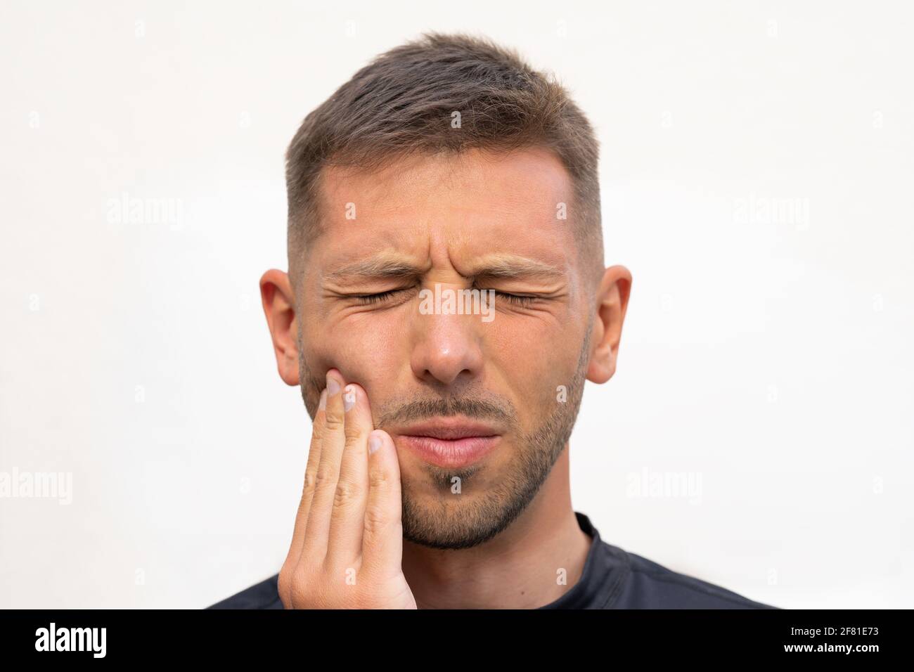 L'uomo sente forte dolore ai denti. Uomo che soffre di mal di denti, malattie dentali o malattie orali. Problema ai denti Foto Stock