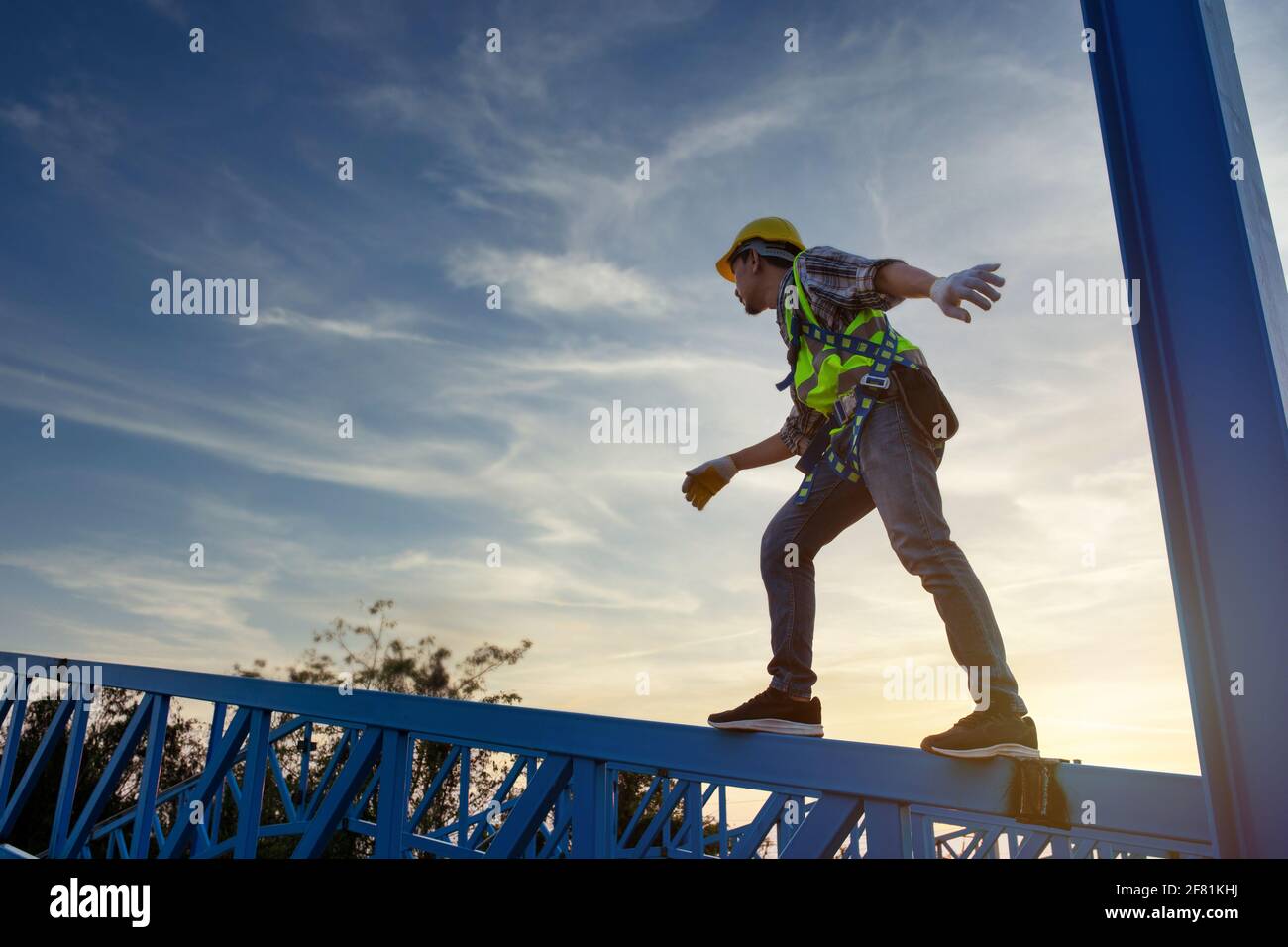 Tecnico tecnico tecnico lavoratore che lavora in una struttura di tetto in metallo di magazzino, lavoratore di costruzione indossare uniforme di sicurezza in altezza ispezione attrezzature meta Foto Stock