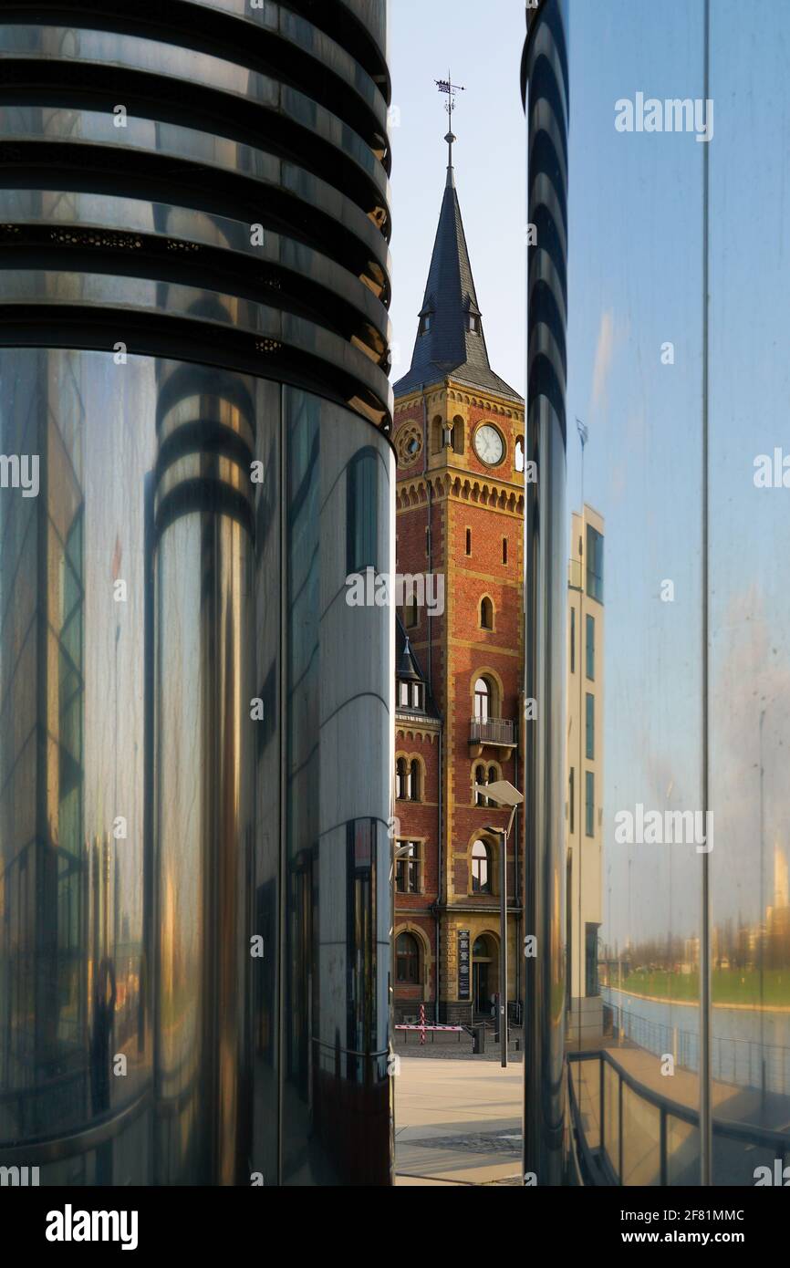 Vecchia torre dell'orologio al Rheinau Hafen a Colonia, Germania tra due tubi di ventilazione metallici Foto Stock