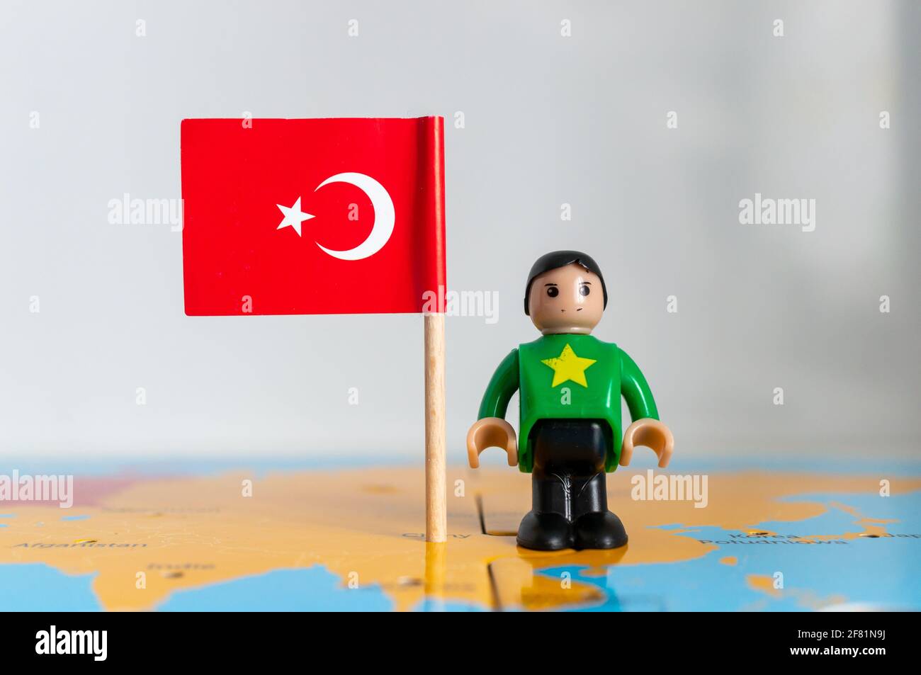 POZNAN, POLONIA - 06 aprile 2021: Figurina giocattolo giocante in piedi accanto ad una bandiera nazionale turca. Foto Stock