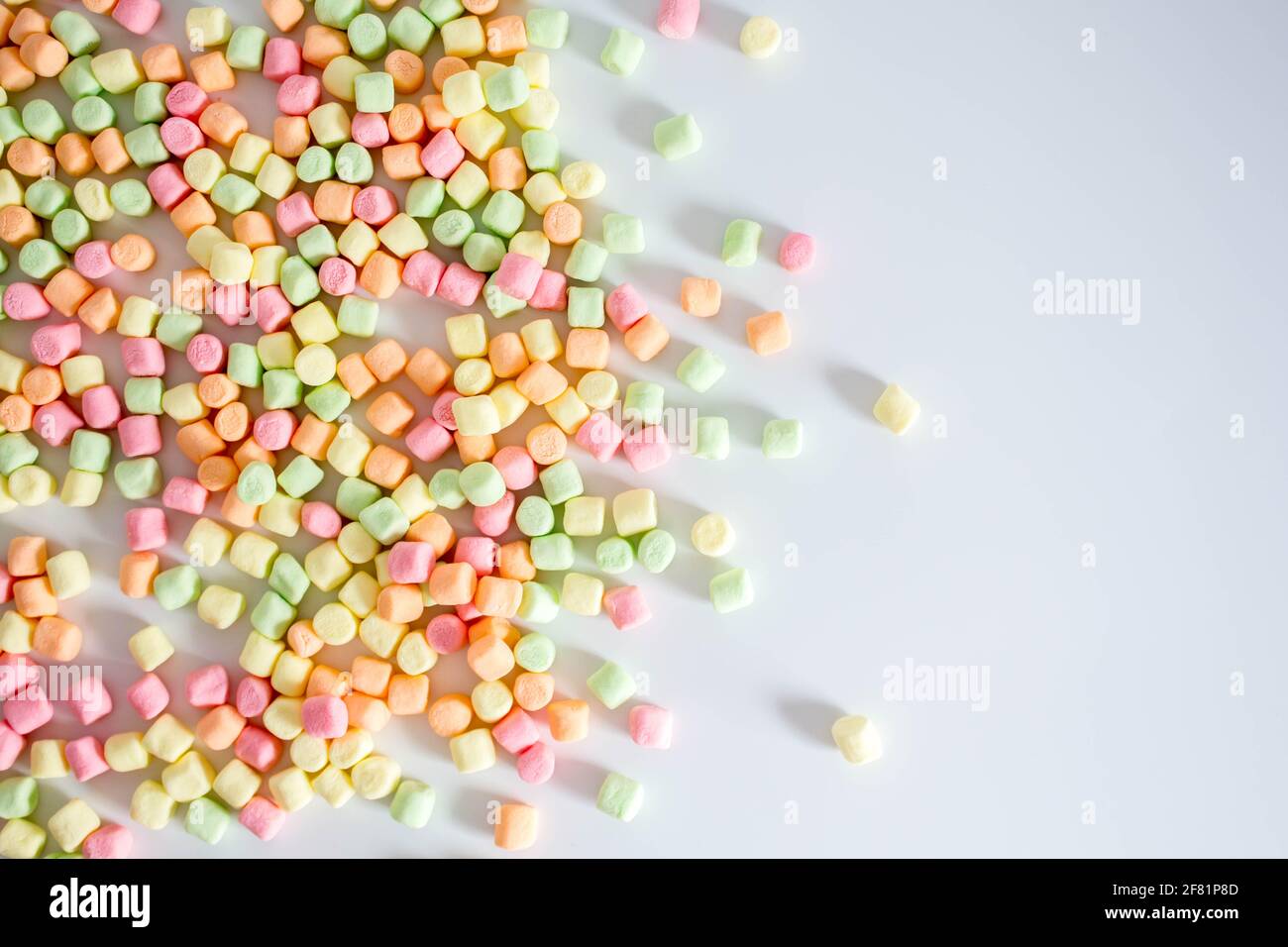 Marshmallows colorati sfondo bianco con spazio di copia. Vista dall'alto Foto Stock