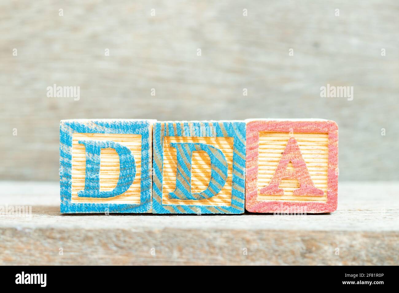 Alfabeto a colori blocco di lettere in parola DDA (abbreviazione di ammortamento, impoverimento e ammortamento o conto deposito domanda) su sfondo legno Foto Stock