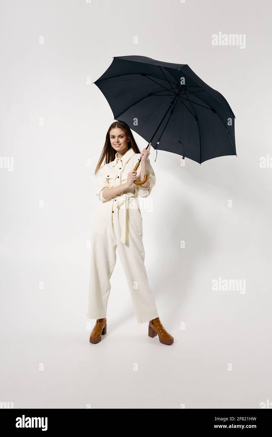 bella donna con ombrello aperto in elegante tuta a intera lunghezza sfondo isolato Foto Stock