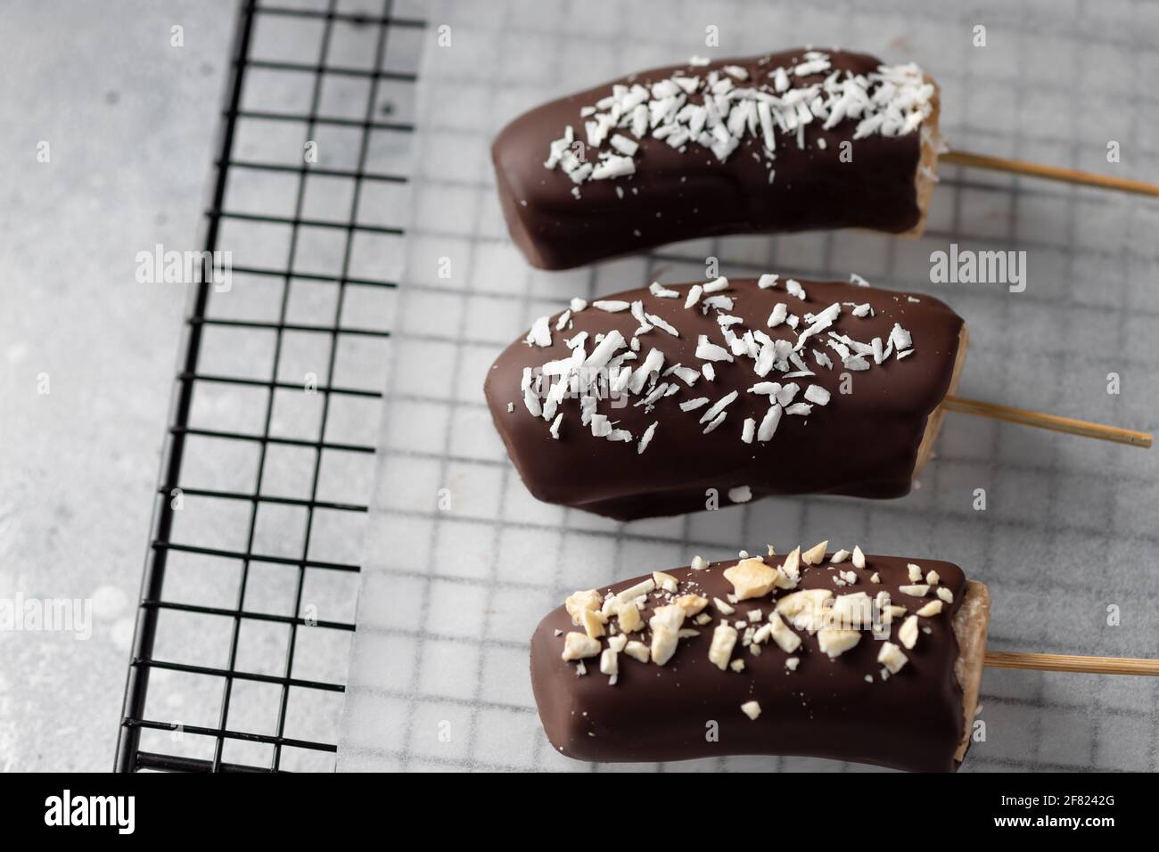 Banane in cioccolato fondente con condimenti Foto Stock
