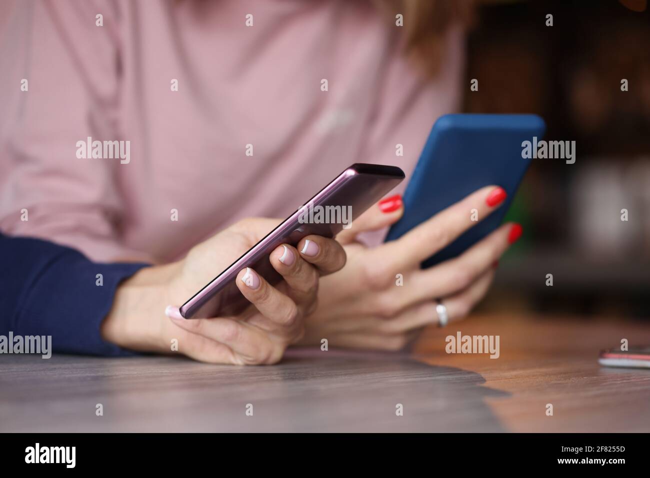 Due smartphone in mani femminili. Closeup chat Foto Stock