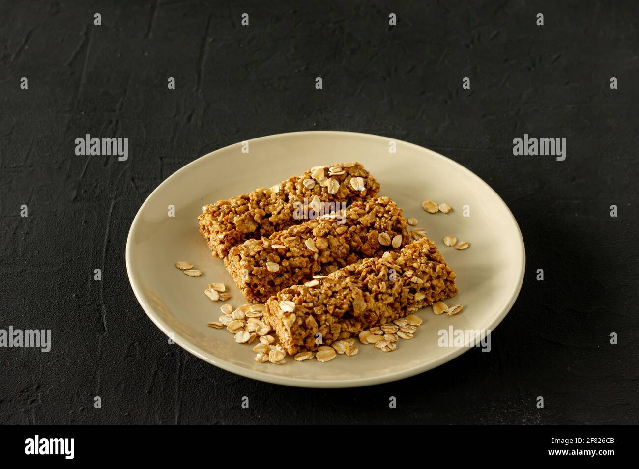 barrette energetiche in granola fatte in casa con mandorle e uvetta su sfondo nero. Cibo sano. Foto Stock