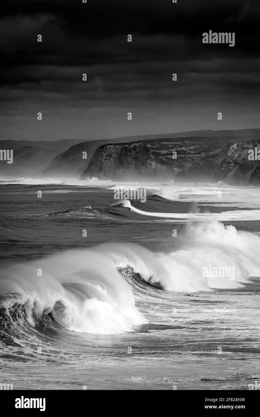 Una serie di onde che si infrangono alla spiaggia di Bordeira (Praia da Bordeira) in Algarve, Portogallo Foto Stock