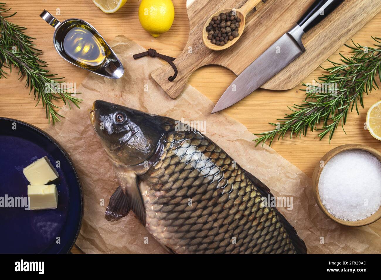 Pesce carpa e ingredienti per cucinare. Preparare cibo sano su tavola di legno. Vista dall'alto del tavolo Foto Stock