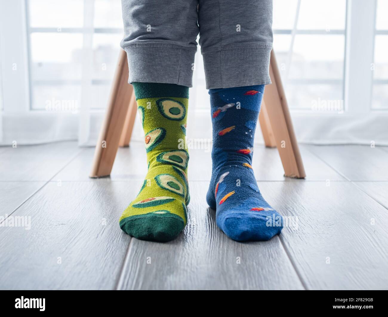 Un primo piano di due calze artistiche diverse sui piedi, con avocado a  sinistra e spazio blu a destra Foto stock - Alamy