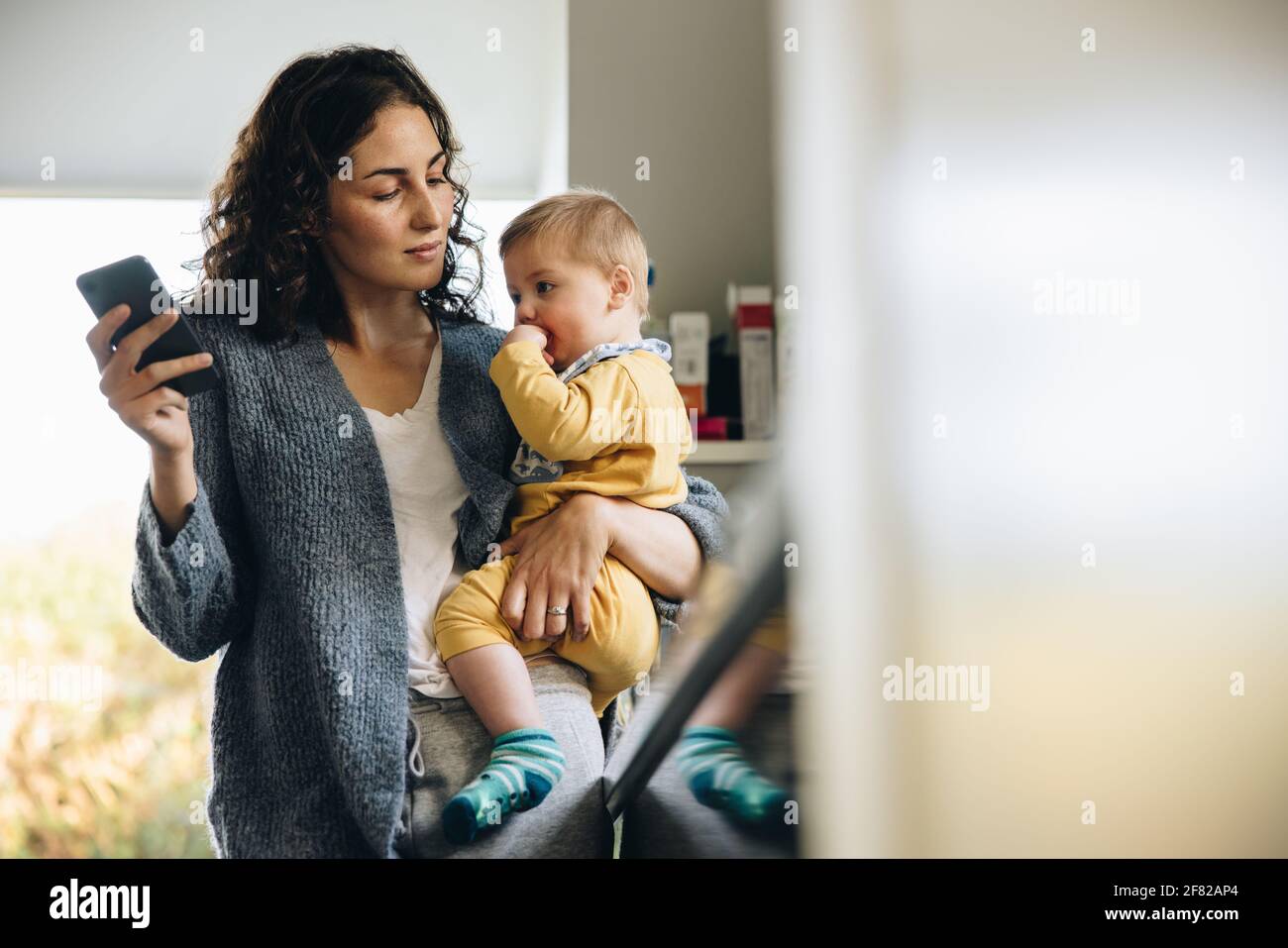 Donna in congedo di maternità che si prende cura di suo figlio. Mamma e bambino a casa. Foto Stock