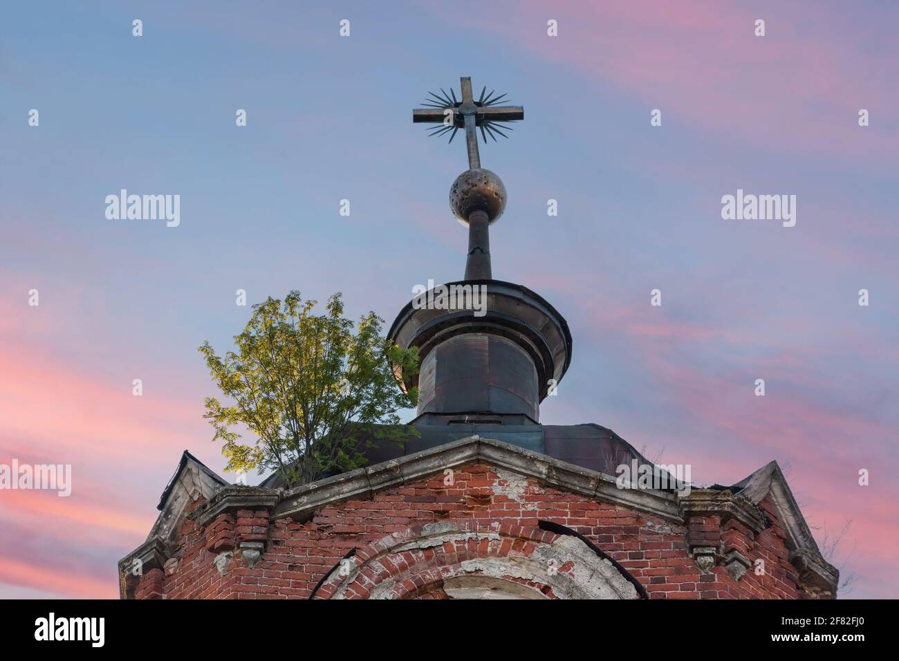 Croce metallica sulla cupola di una chiesa abbandonata Foto Stock