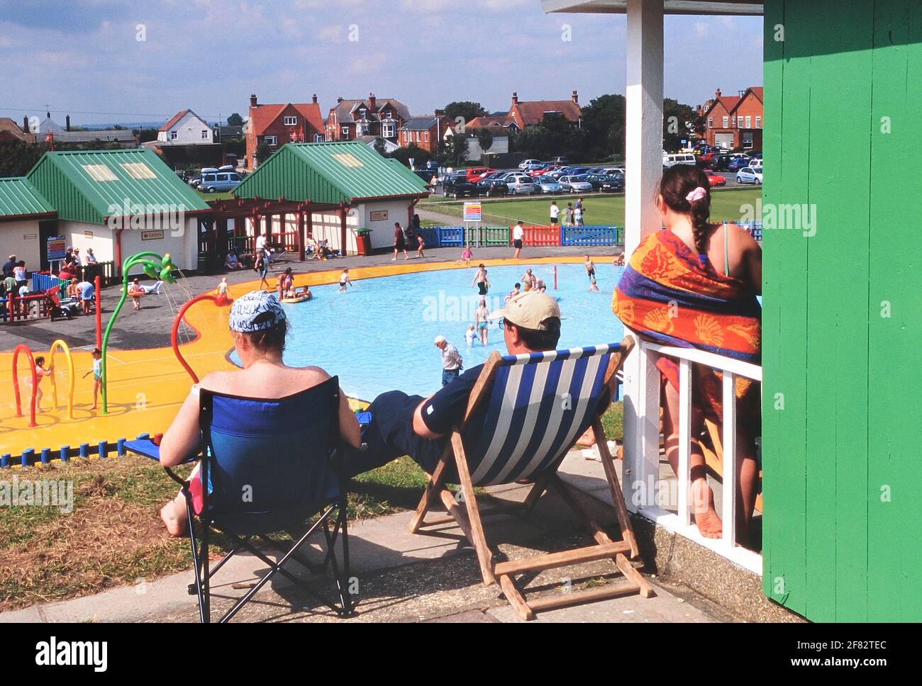 I vacanzieri presso il loro chalet sulla spiaggia vicino alla piscina con spruzzi del Queen's Park. Mablethorpe. Lincolnshire. Inghilterra, Regno Unito Foto Stock