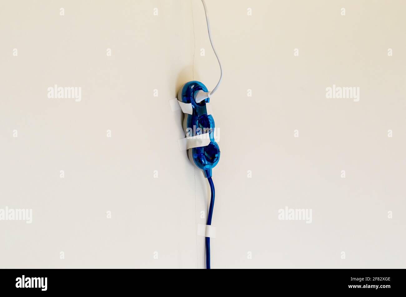 Un'immagine di una prolunga con nastro adesivo su parete Foto Stock
