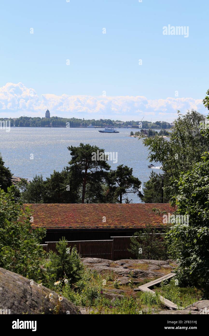 Una vista dall'isola dello zoo di Korkeasaari verso il centro di Helsinki, giugno 2019. Giorno estivo soleggiato. È possibile vedere la foresta, le barche e gli edifici della capitale. Foto Stock