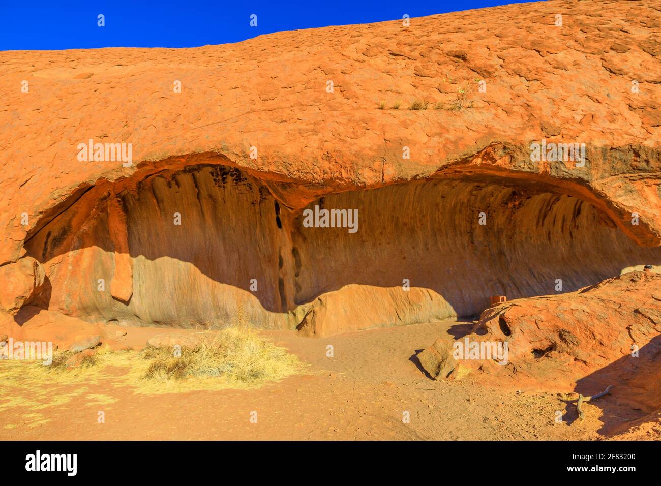 Formazione rocciosa a forma d'onda o Kitchen Cave lungo Mala Walk alla base di Ayers Rock nel Parco Nazionale Uluru-Kata Tjuta nel territorio del Nord, Australia Foto Stock