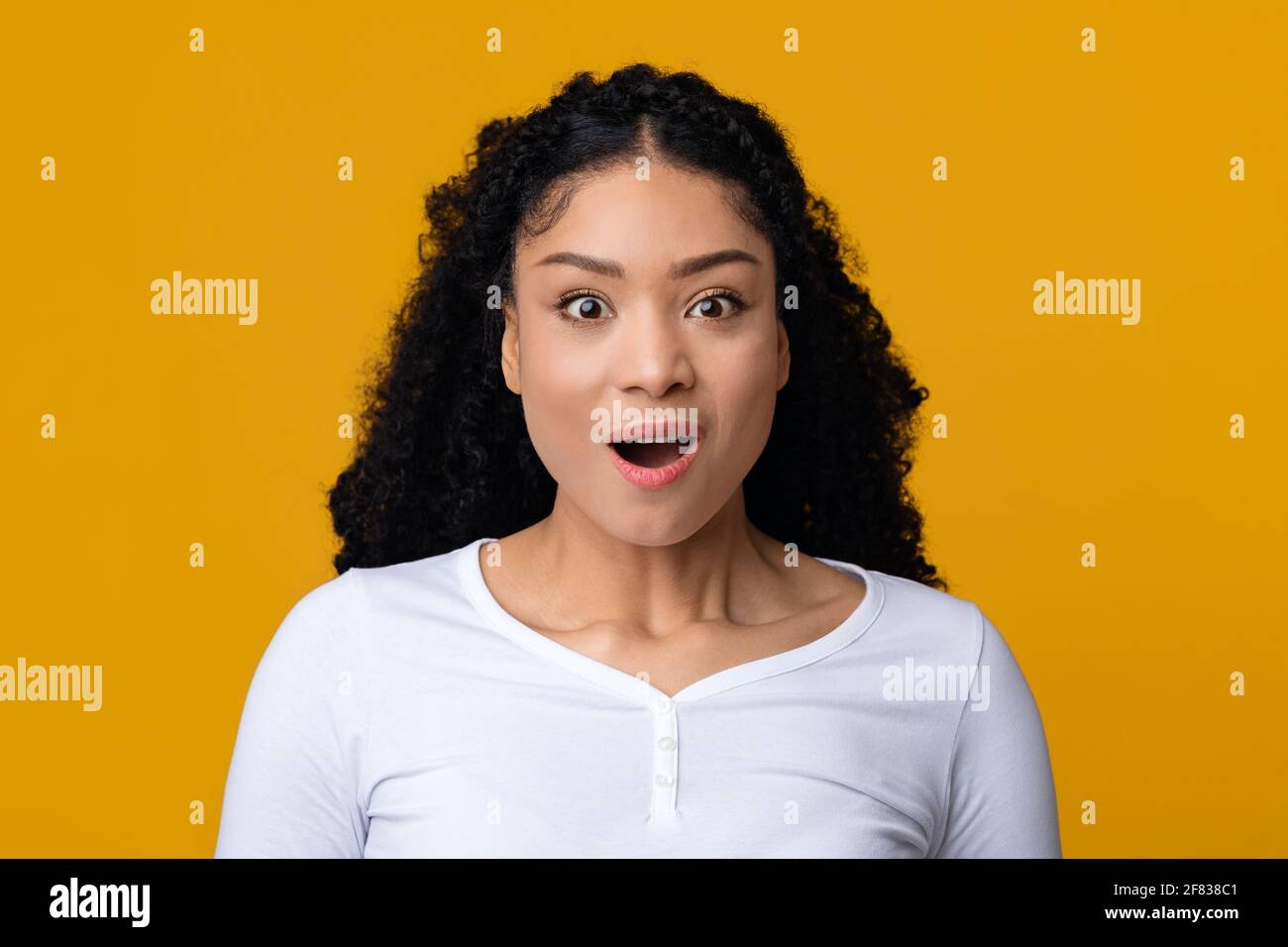 WOW. Ritratto di sorprendente Black Lady apertura bocca in eccitazione Foto Stock