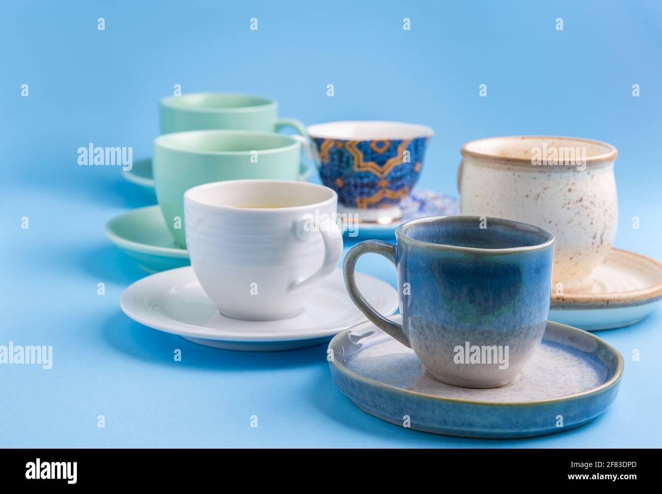diversi tipi di tazze e piattini di caffè su un blu sfondo Foto Stock