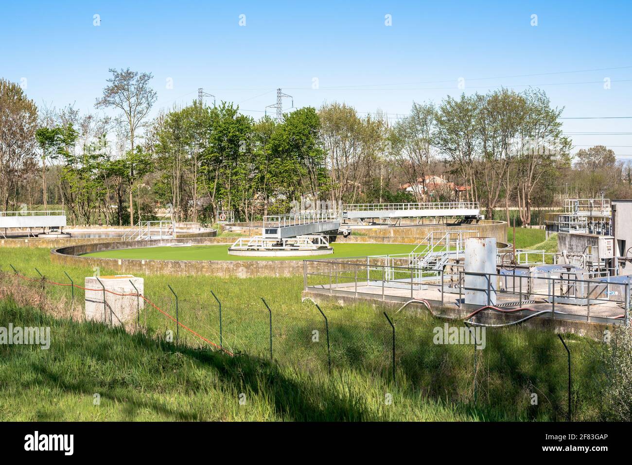 Serbatoi rotondi in un impianto di trattamento delle acque reflue in campagna in una chiara mattina di primavera Foto Stock