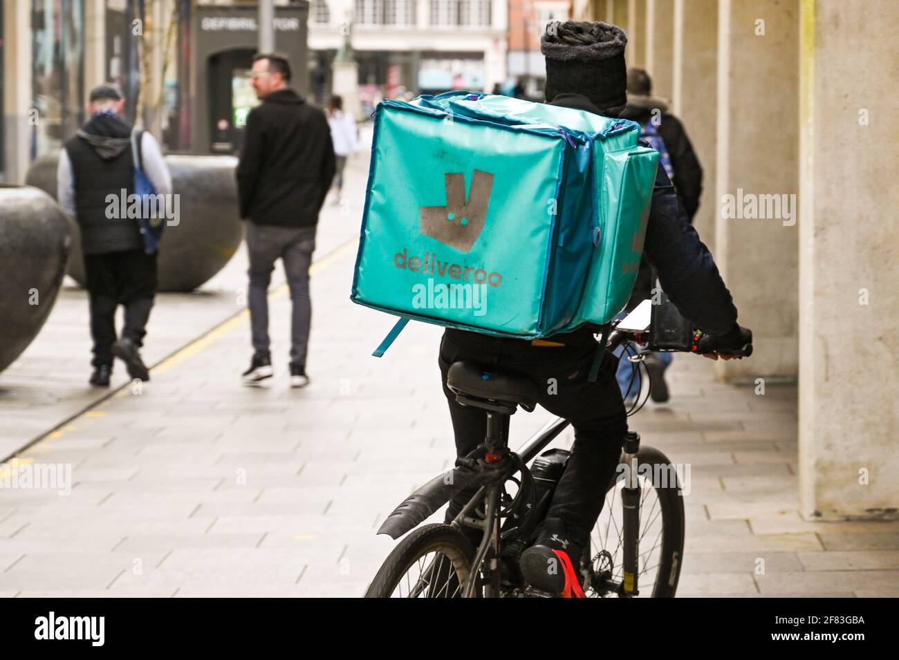 Cardiff, Galles - Aprile 2021: Persona in bicicletta nel centro di Cardiff che effettua una consegna per Deliveroo. Foto Stock