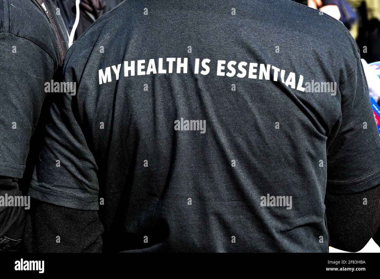 Messaggio sull'importanza della salute sul retro della T-shirt di una persona. Foto Stock