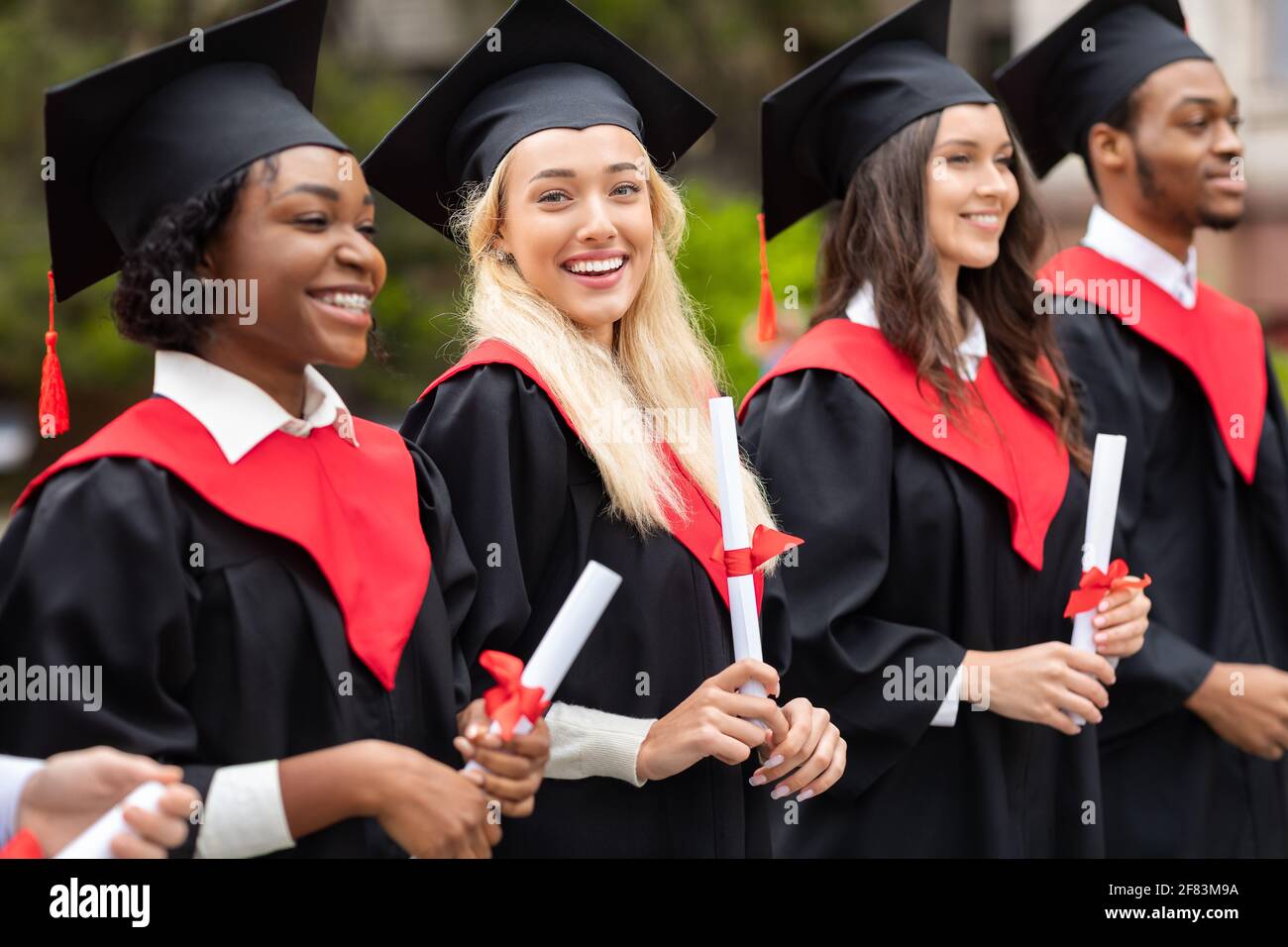 Bella signora bionda in piedi tra il gruppo internazionale di studenti Foto Stock