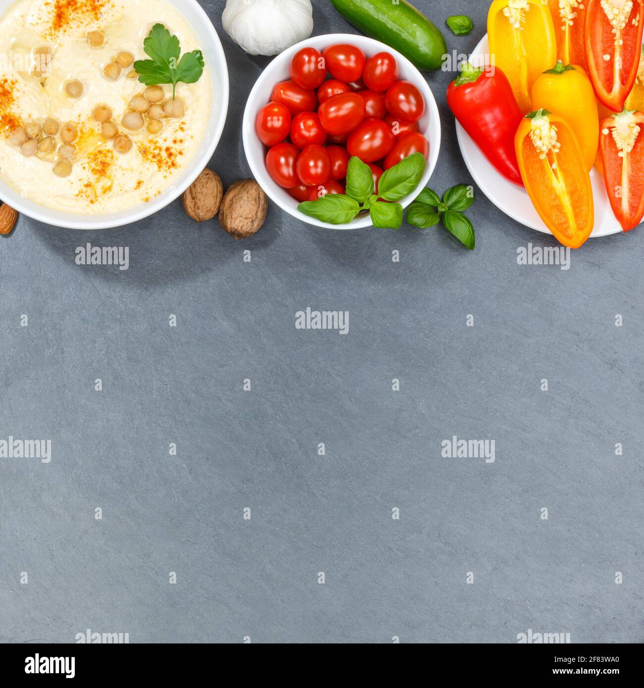 Verdure di fondo vegano sano pulito mangiare cibo organico su un spazio copyspace di ardesia quadrato Foto Stock