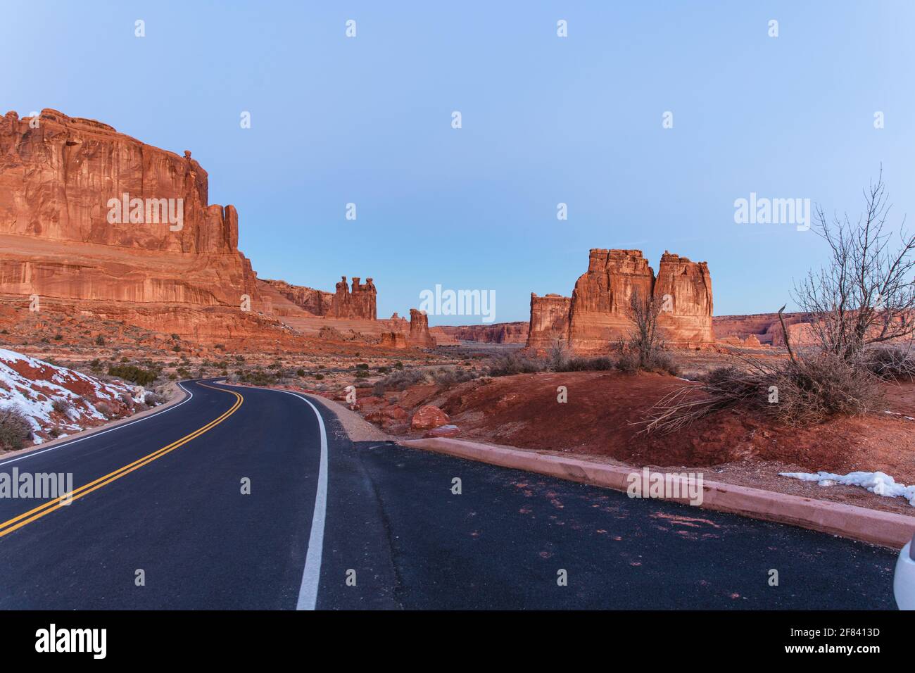 strada nel mezzo di un deserto con roccia rossa formazione Foto Stock